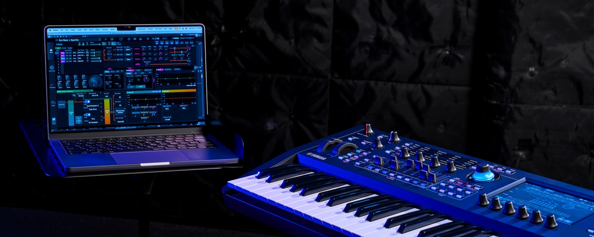 Image representing the WORKFLOW feature, showing a PC and synthesizer side by side in a moody lighting setup