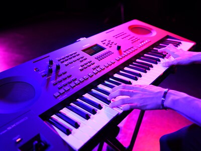 Close-up of hands playing a keyboard during a live performance.