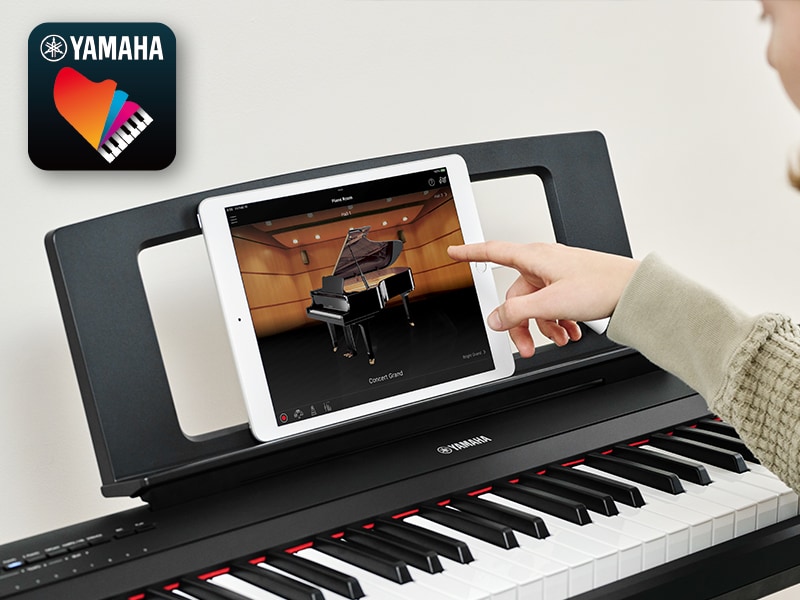 The Yamaha “Smart Pianist” app icon, together with a tablet placed on the music stand of the Piaggero